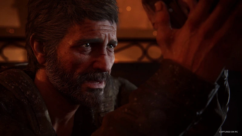 A close-up of Joel in warm lighting in The Last of Us Part I