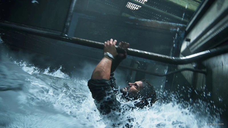 Joel grips an overhead pipe above floodwater in The Last of Us Part I