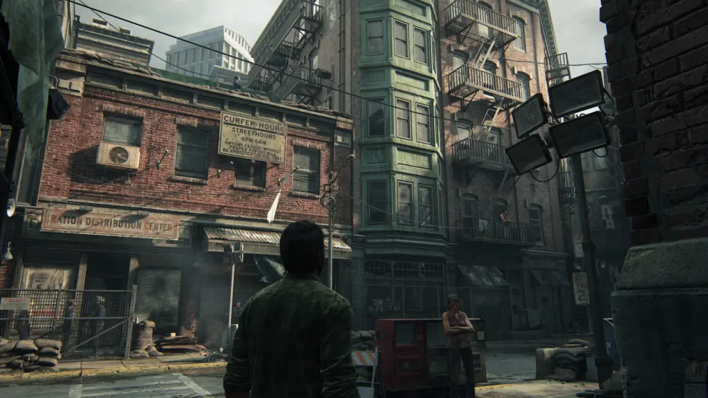 Joel looks up at buildings on a quarantine-zone street in The Last of Us Part I