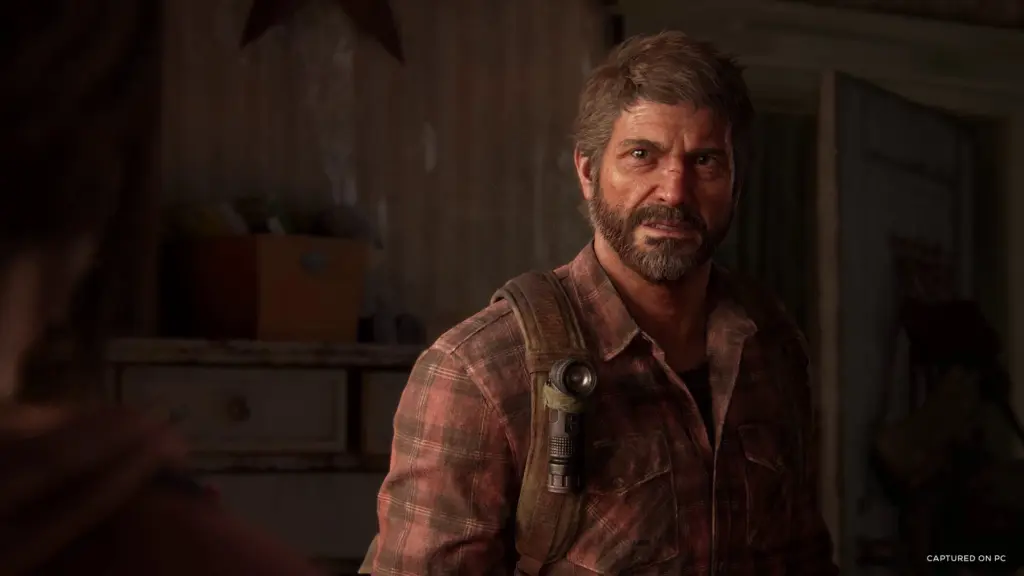 A close-up of Joel indoors in The Last of Us Part I