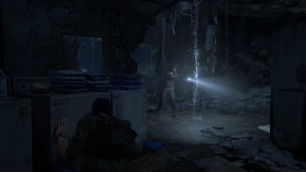 A flashlight illuminates a dark, damaged room in The Last of Us Part I