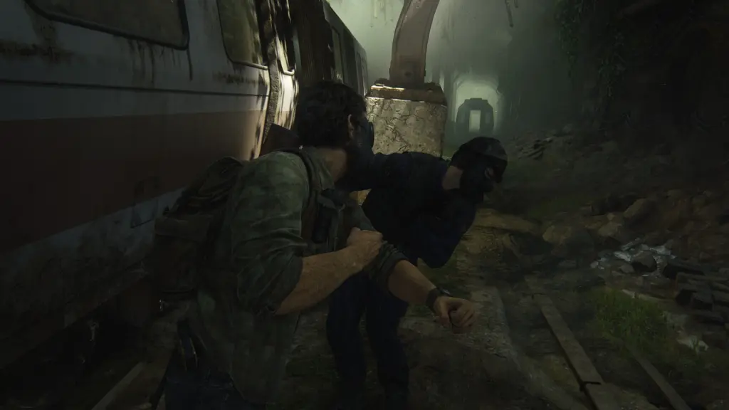 Joel grapples with a masked attacker beside a train in The Last of Us Part I