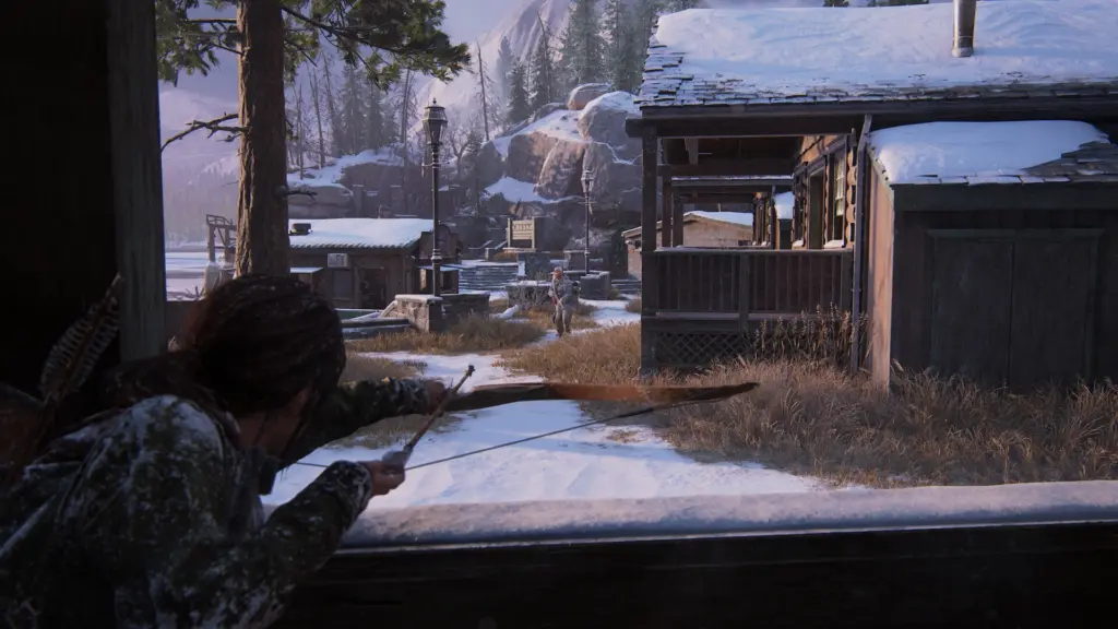 Ellie aims a bow in a snowy settlement in The Last of Us Part I